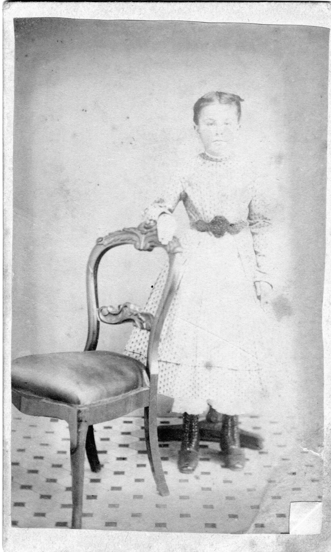 vintage image of a girl standing next to a chair. She is barely visible as if overexposed or faded.