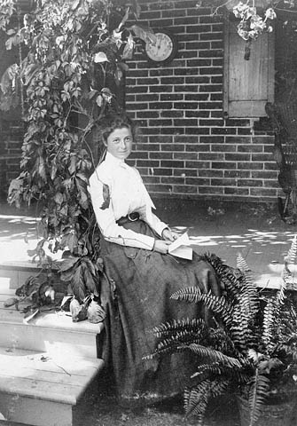 vintage photo of a woman sitting on steps holding a letter